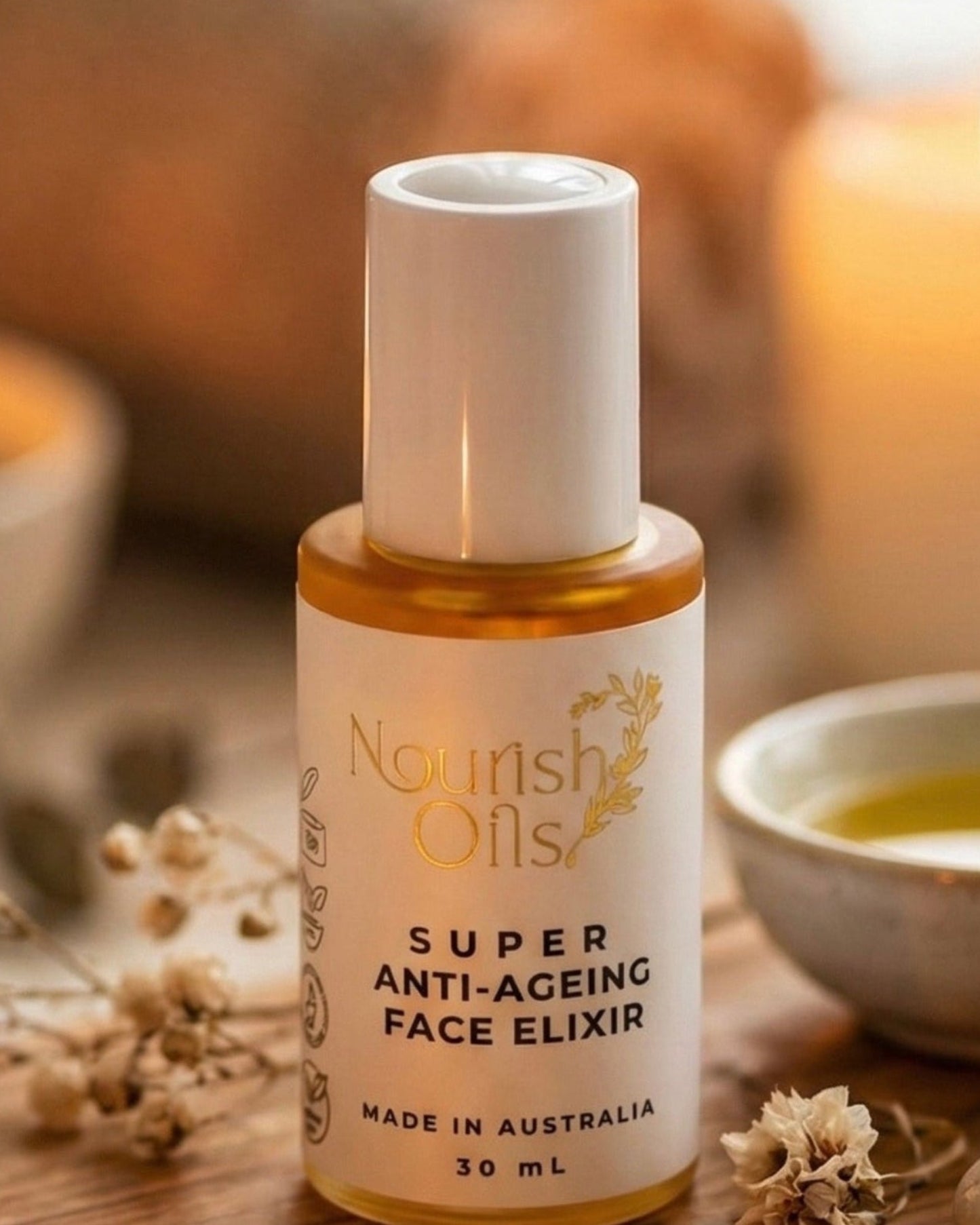 Bottle of 'Nourish Oils' face elixir on a wooden board with candles and stones in the background