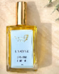 Body oil bottle labeled 'Unwind' on a marble surface with eucalyptus leaves.