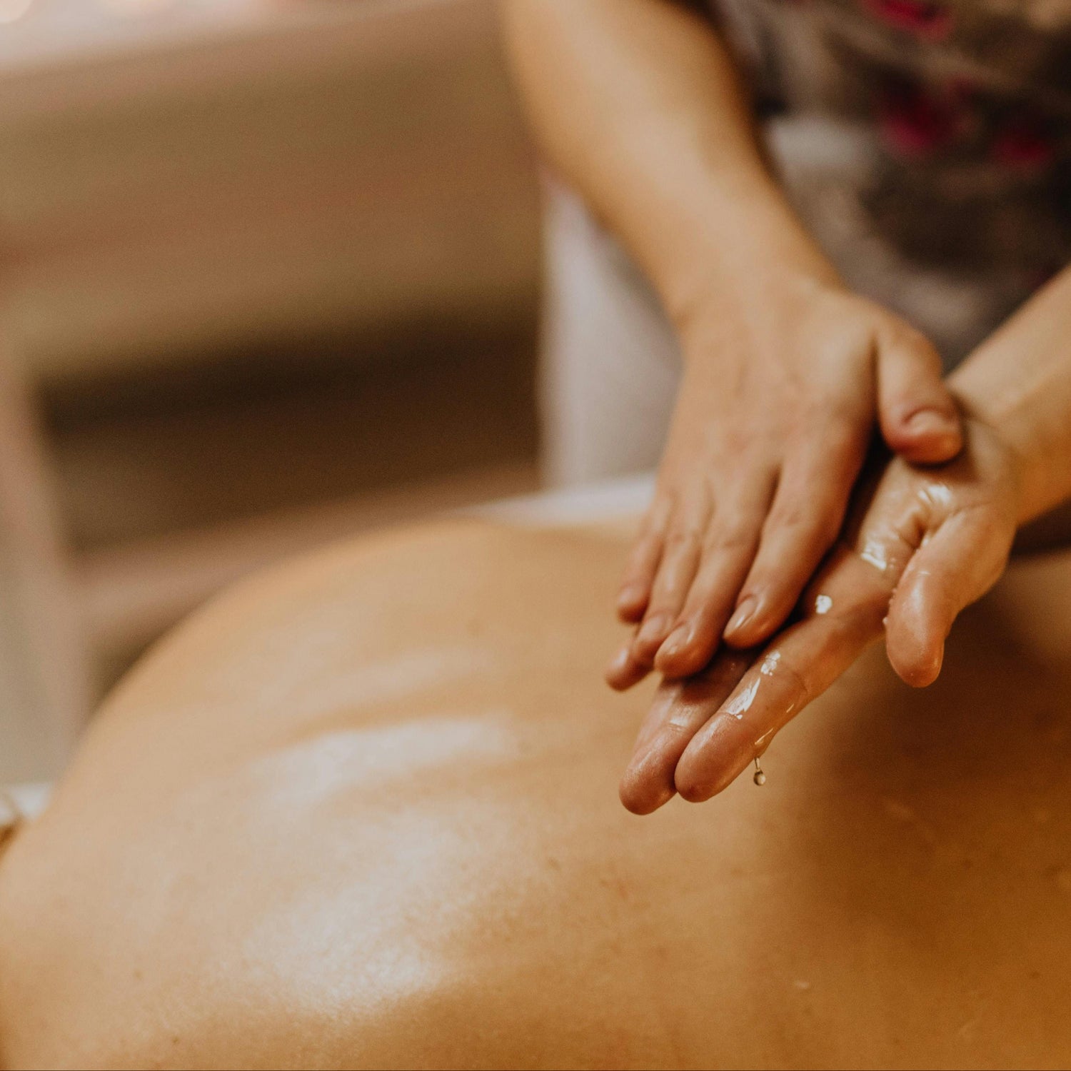 Person receiving a massage with hands on a blurred background