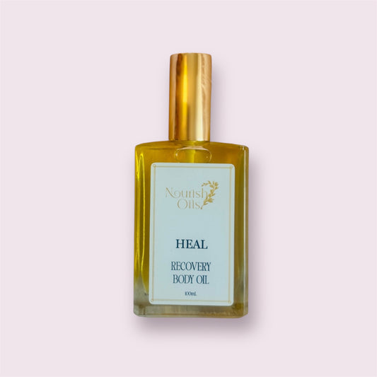 Nourish Oils Heal Massage Oil surrounded by raw turmeric root, arnica flowers, and peppermint leaves, highlighting anti-inflammatory botanicals."
